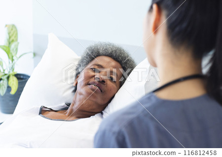 Senior African American woman lies in a hospital bed, with copy space 116812458