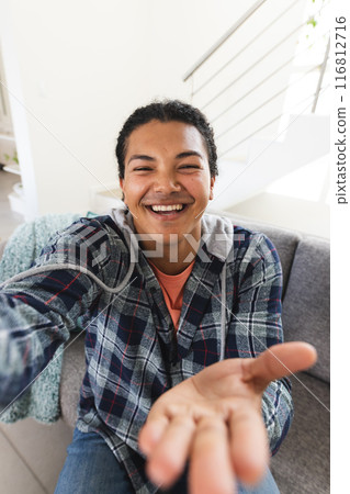 Young biracial man smiling during a video call at home, with copy space 116812716