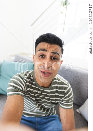 Middle Eastern man takes a selfie during a video call at home, with copy space 116812717