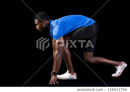 African American athlete in starting position on a black background, with copy space African American athlete in starting position on a black background, with copy space 116812784