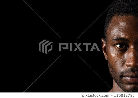 Intense gaze from an African American man, with copy space on a black background Intense gaze from an African American man, with copy space on a black background 116812785