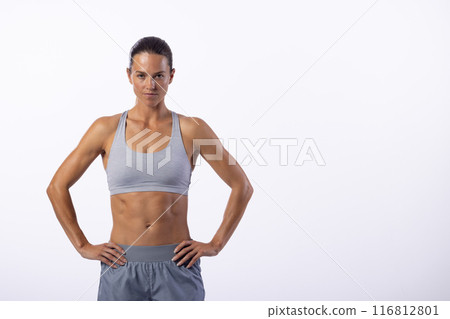 A confident young Caucasian female athlete poses, white background, copy space 116812801