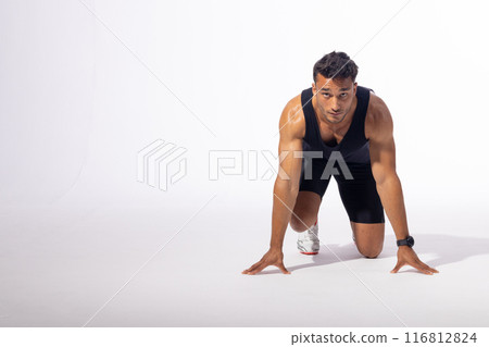 Young biracial man in a runner's starting position, with copy space on white background 116812824