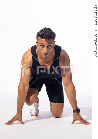 Young biracial man in a runner's starting position on white background 116812825
