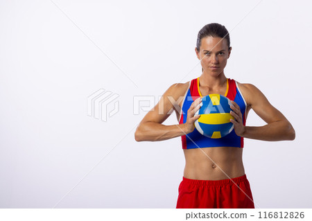 Young Caucasian woman holds a volleyball in a studio setting on a white background with copy space 116812826