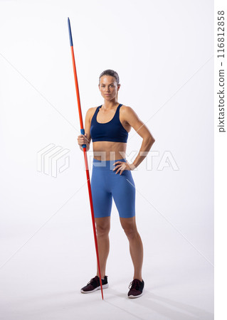 Athletic young Caucasian female athlete poses with a javelin on a white background 116812858