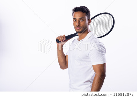 Confident young biracial man poses with a tennis racket on a white background, with copy space Confident young biracial man poses with a tennis racket on a white background, with copy space 116812872