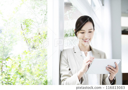 Business woman who works on tablet Business woman who works on tablet 116813083