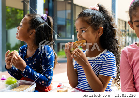 Three biracial girls enjoy a lunch during a break at school Three biracial girls enjoy a lunch during a break at school 116813226