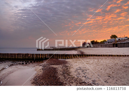 View of sand beach with wooden breakwaters on the Baltic Sea coast on sunrise in Zelenogradsk. Russia View of sand beach with wooden breakwaters on the Baltic Sea coast on sunrise in Zelenogradsk. Russia 116813738