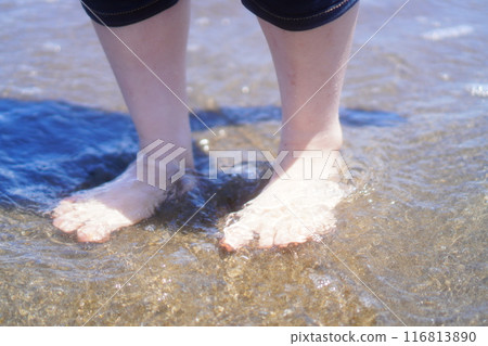 The feet of a woman playing in the sea The feet of a woman playing in the sea 116813890