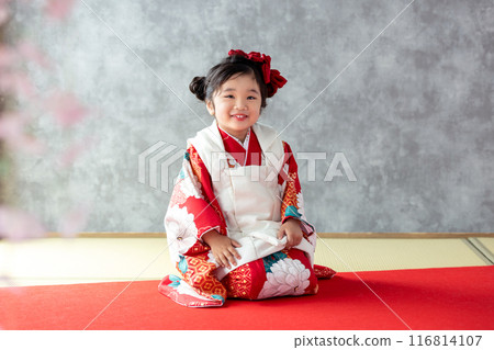 A girl wearing a kimono sitting upright 116814107