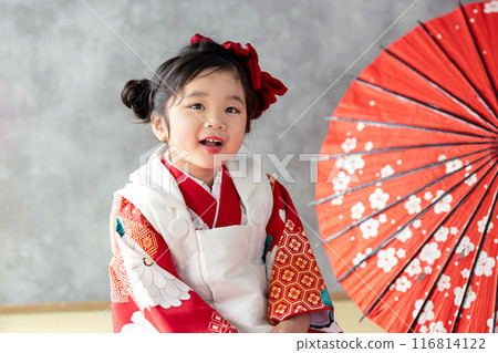 A girl wearing a kimono sitting upright A girl wearing a kimono sitting upright 116814122