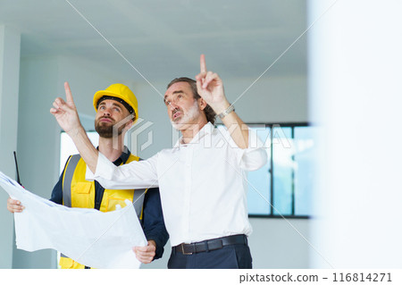 Portrait of caucasian male real estate customer talking - discussing with male building foreman - engineer about construction and interior works. Construction contractor talking with client. 116814271