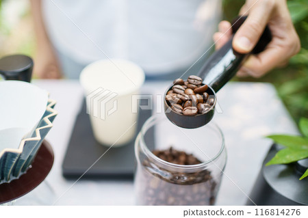 Happy Asian beautiful woman making a specialty coffee in morning at her backyard garden, woman brewing a coffee by dripping or pouring over a hot water. Happy Asian beautiful woman making a specialty coffee in morning at her backyard garden, woman brewing a coffee by dripping or pouring over a hot water. 116814276