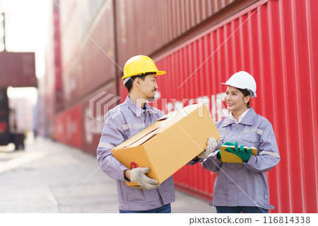 Team of logistic engineer working at the container yard. Asian female and male container yard worker talking - discussing together. Team of logistic engineer working at the container yard. Asian female and male container yard worker talking - discussing together. 116814338