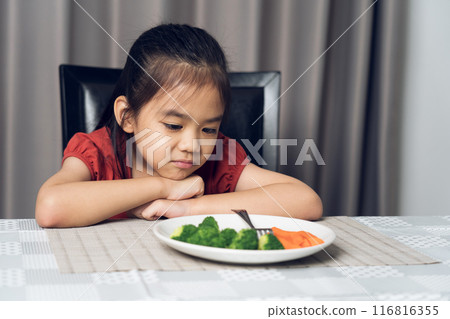 Little cute kid girl refusing to eat healthy vegetables. Children do not like to eat vegetables. Little cute kid girl refusing to eat healthy vegetables. Children do not like to eat vegetables. 116816355