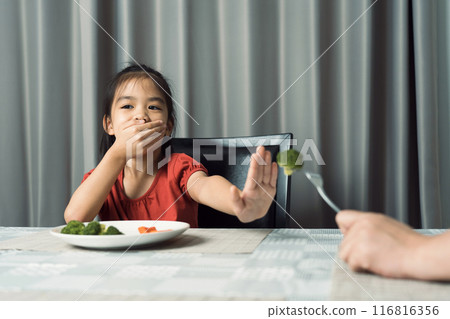 Little cute kid girl refusing to eat healthy vegetables. Children do not like to eat vegetables. 116816356