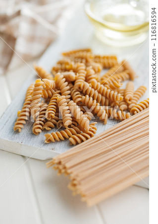 Uncooked whole grain pasta. Raw fusilli and spaghetti. 116816594