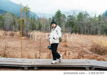 Woman tourist travel Kamikochi National Park, happy Traveler sightseeing meadow fields with mountain, Nagano Prefecture, Japan. Landmark for tourists attraction. Japan Travel, Destination and Vacation 116816787