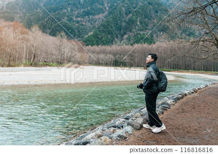 man  tourist travel Kamikochi National Park, happy Traveler sightseeing Azusa river with mountain, Nagano Prefecture, Japan. Landmark for tourists attraction. Japan Travel, Destination and Vacation 116816816