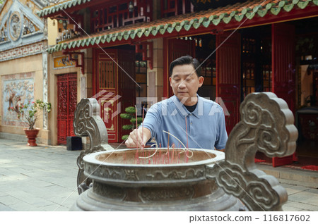 Man Putting Aroma Sticks In Cup Man Putting Aroma Sticks In Cup 116817602