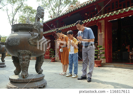 Asian Family Worshiping The Buddhist Faith 116817611