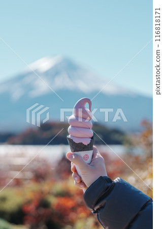 Woman hand holding ice cream in a cone with Mt Fuji at Lake Kawaguchi, happy Traveler sightseeing Mount Fuji in Oishi park. Landmark for tourists attraction. Japan Travel, Destination and Vacation Woman hand holding ice cream in a cone with Mt Fuji at Lake Kawaguchi, happy Traveler sightseeing Mount Fuji in Oishi park. Landmark for tourists attraction. Japan Travel, Destination and Vacation 116818171