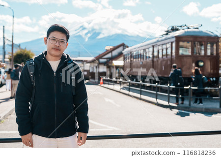 man tourist with Fuji Mountain at Kawaguchiko train station, happy Traveler sightseeing Mount Fuji in Yamanashi, Japan. Landmark for tourists attraction. Japan Travel, Destination and Vacation 116818236