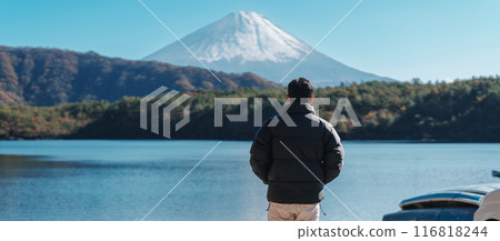 man  tourist enjoy with Fuji Mountain at Lake Saiko, happy Traveler sightseeing Mount Fuji and road trip Fuji Five Lakes. Landmark for tourists attraction. Japan Travel, Destination and Vacation 116818244