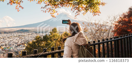Woman tourist with mount Fuji at Chureito Pagoda in Autumn season, Traveler travel Arakurayama Sengen Park, Yamanashi, Japan. Landmark for tourist attraction. Japan Travel, Destination and Vacation 116818373