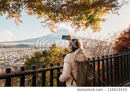 Woman tourist with mount Fuji at Chureito Pagoda in Autumn season, Traveler travel Arakurayama Sengen Park, Yamanashi, Japan. Landmark for tourist attraction. Japan Travel, Destination and Vacation 116818410