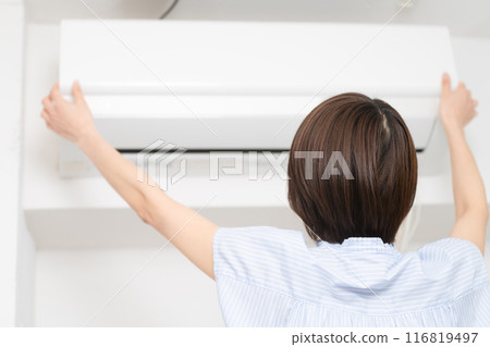 Young woman cleaning air conditioner filters Lifestyle image Young woman cleaning air conditioner filters Lifestyle image 116819497