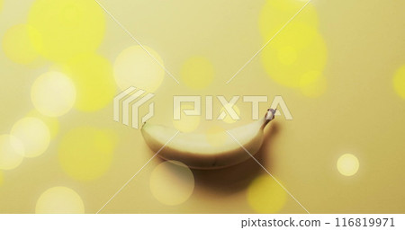 Composition of spots of light over banana on yellow background 116819971