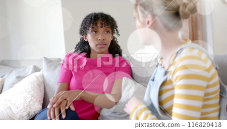 Image of light spots over two diverse teenage girls talking on couch Image of light spots over two diverse teenage girls talking on couch 116820418