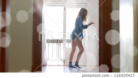 Image of light spots over happy caucasian teenage girl dancing at home 116820427