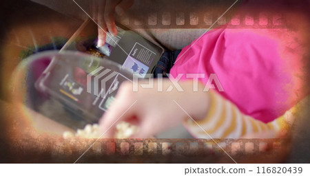 Image of film frame over midsection of diverse teenage girls using tablet eating popcorn at home Image of film frame over midsection of diverse teenage girls using tablet eating popcorn at home 116820439