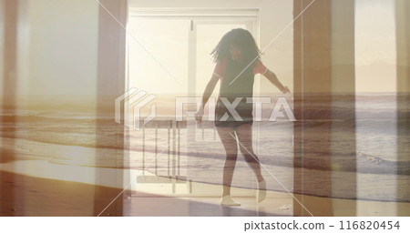 Image of sunset beach over biracial teenage girl dancing at home Image of sunset beach over biracial teenage girl dancing at home 116820454