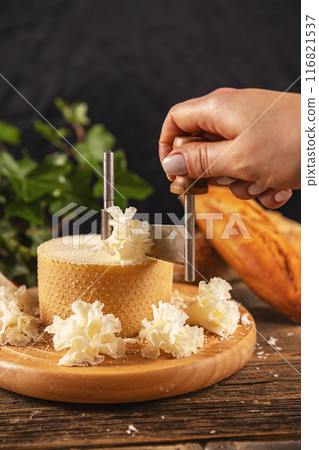 Woman slicing cheese with girolle Woman slicing cheese with girolle 116821537