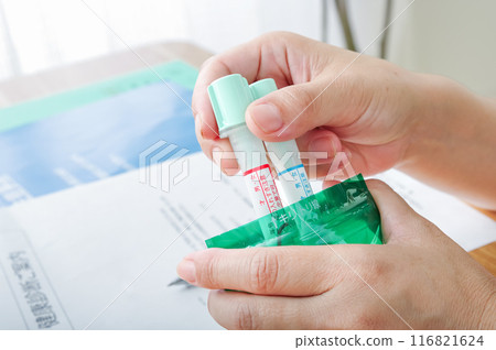 一名婦女將糞便測試容器放入袋中 一名婦女將糞便測試容器放入袋中 116821624