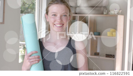 Image of light spots over happy caucasian teenage girl holding yoga mat 116822591