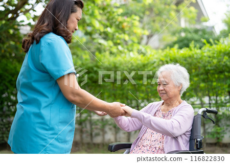 Doctor help and care Asian senior woman patient sitting on wheelchair at park in nursing hospital ward, healthy strong medical concept. Doctor help and care Asian senior woman patient sitting on wheelchair at park in nursing hospital ward, healthy strong medical concept. 116822830