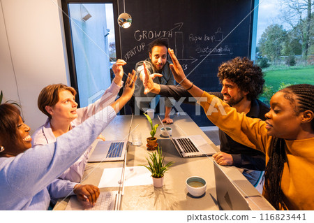 Team collaboration meeting in the office with highfives to celebrate achievements and success 116823441