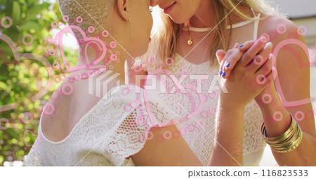 Image of hearts floating over diverse female married couple dancing Image of hearts floating over diverse female married couple dancing 116823533