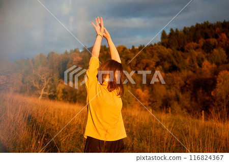 a portrait  young woman in mustard sweater in autumn mountains at sunset 116824367