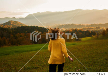 a young woman in mustard sweater in autumn mountains at sunset a young woman in mustard sweater in autumn mountains at sunset 116824371