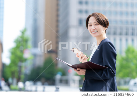 Middle-aged business woman working in an office district Middle-aged business woman working in an office district 116824660