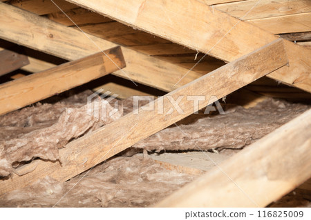 Construction worker thermally insulating house mineral wool attic with glass wool Construction worker thermally insulating house mineral wool attic with glass wool 116825009