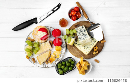 Different kinds of cheese served with green olives, tomato and grape for gourmet nutrition. Organic parmesan and brie delicatessen Different kinds of cheese served with green olives, tomato and grape for gourmet nutrition. Organic parmesan and brie delicatessen 116826458