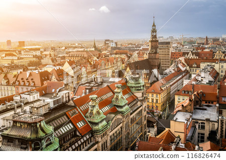 Aerial view on Medieval architecture of Wroclaw city in Poland. Fairy scenic old center part with colorful roofs and houses of Wroclaw at sunset. Aerial view on Medieval architecture of Wroclaw city in Poland. Fairy scenic old center part with colorful roofs and houses of Wroclaw at sunset. 116826474